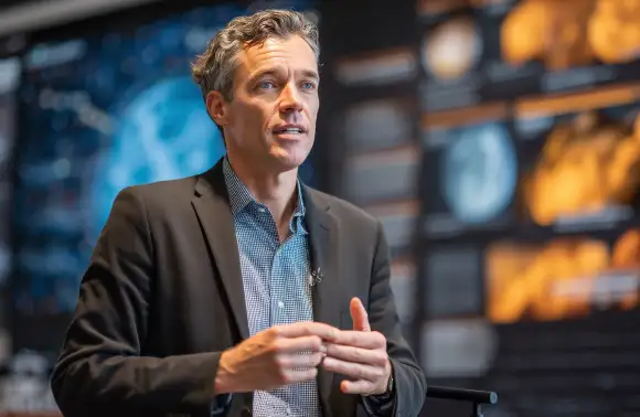 Hombre observado el cielo con su telescopio y su computadora, ya sea sacando calculos, viendo fotografías o cuerpos celestes, etc.