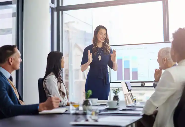 Fotografía de un hombre y una mujer mirando datos de resultados de una estrategia organizacional en una tableta dentro de una oficina de una empresa de tecnología.