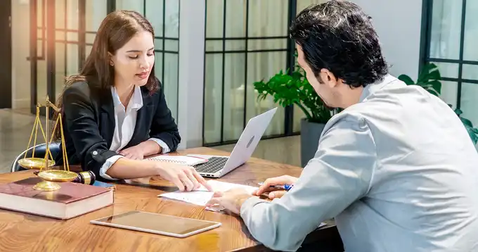 Profesional asesorando a un colaborador de una empresa sobre el derecho del consumo y sus obligaciones.