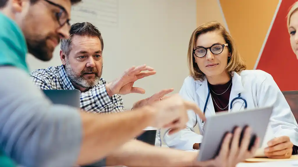Una especialista de marketing en salud presentando una estrategia de mercadeo al director de un hospital