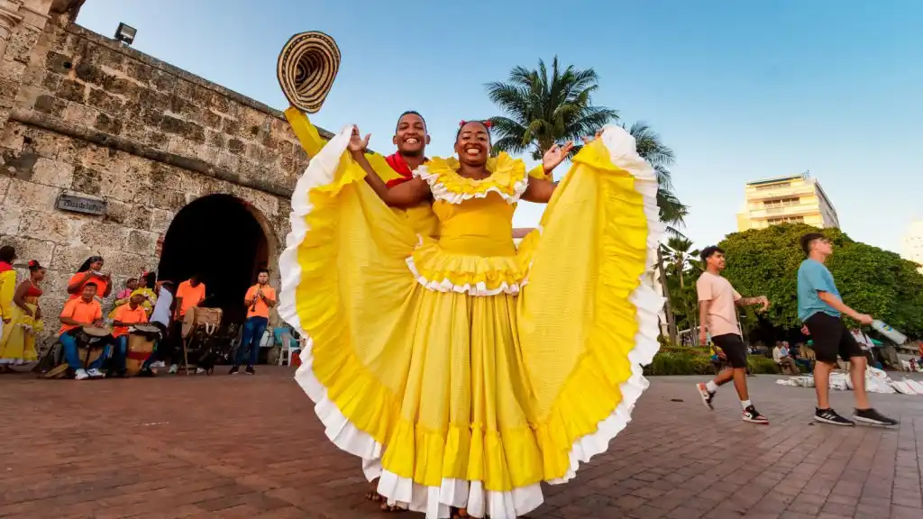 Imagen que muestra a personas en la calle de diferentes edades, géneros, caminando y disfrutando de un carnaval, como muestra de la gestión cultural en Colombia.