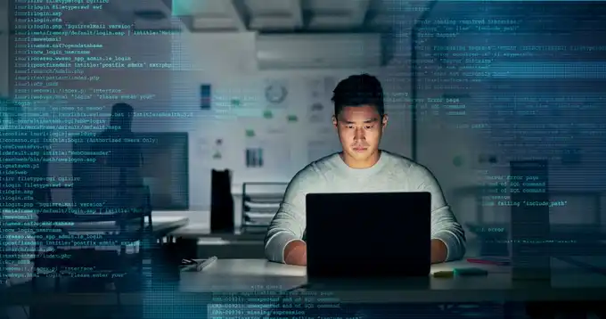 Un hombre trabaja en una sala de cómputo frente a una pantalla.
