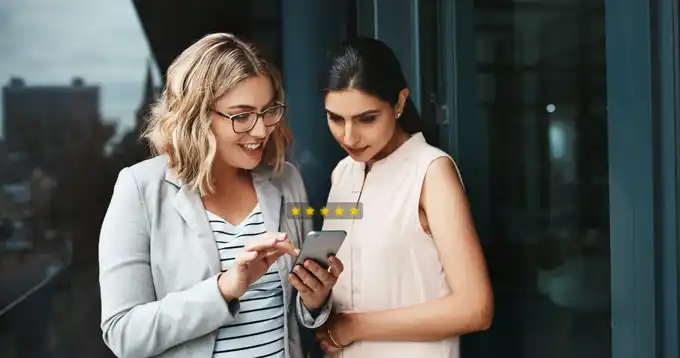 Dos mujeres mirando un smartphone afuera de la oficina