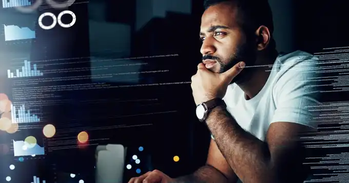 Un hombre observando una pantalla de computadora con datos en ella.