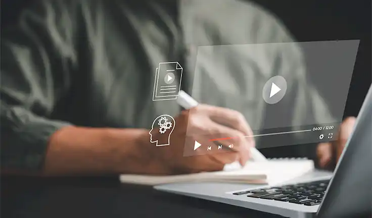 Persona usando una computadora portátil, con íconos educativos digitales proyectados desde la pantalla, simbolizando el concepto de e-learning.