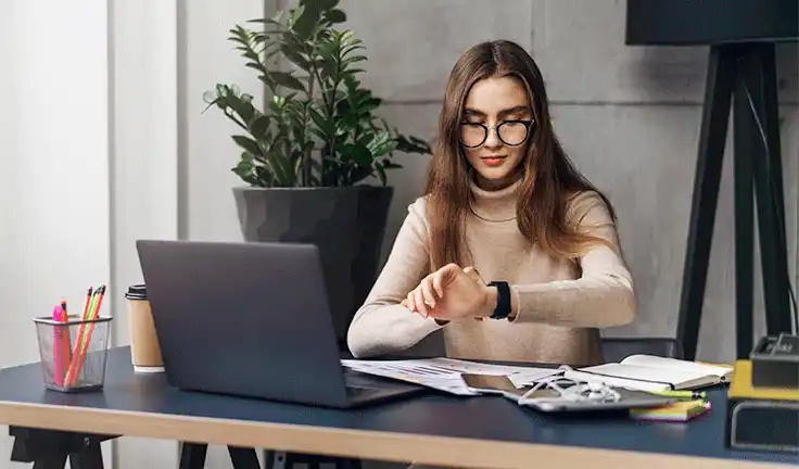 Estudiante revisando su reloj mientras estudia en casa, aplicando gestión del tiempo y técnicas de organización
