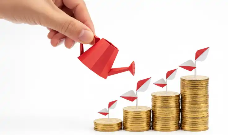 Imagen que muestra una mano regando monedas de las que salen plantas, representando el concepto de sostenibilidad y formación financiera.