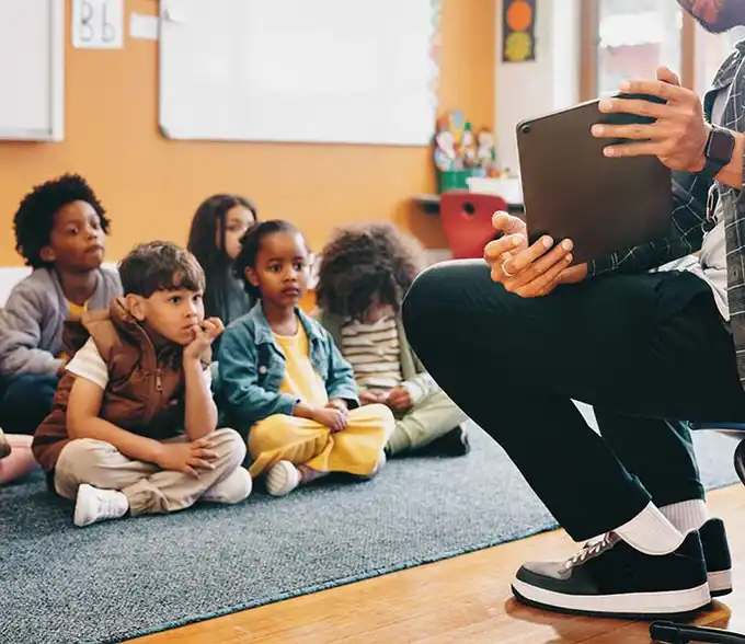 Profesor imparte clases a niños y niñas en etapa de educación inicial
